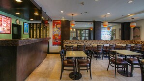 A restaurant interior with a counter, seating area, and decorative elements. - Fersal Hotel Malakas (Quezon City)