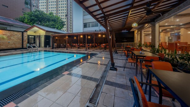 A rooftop pool area with a covered seating area and a view of tall buildings in the background. - Hotel Marcopolo Jakarta (Jakarta)