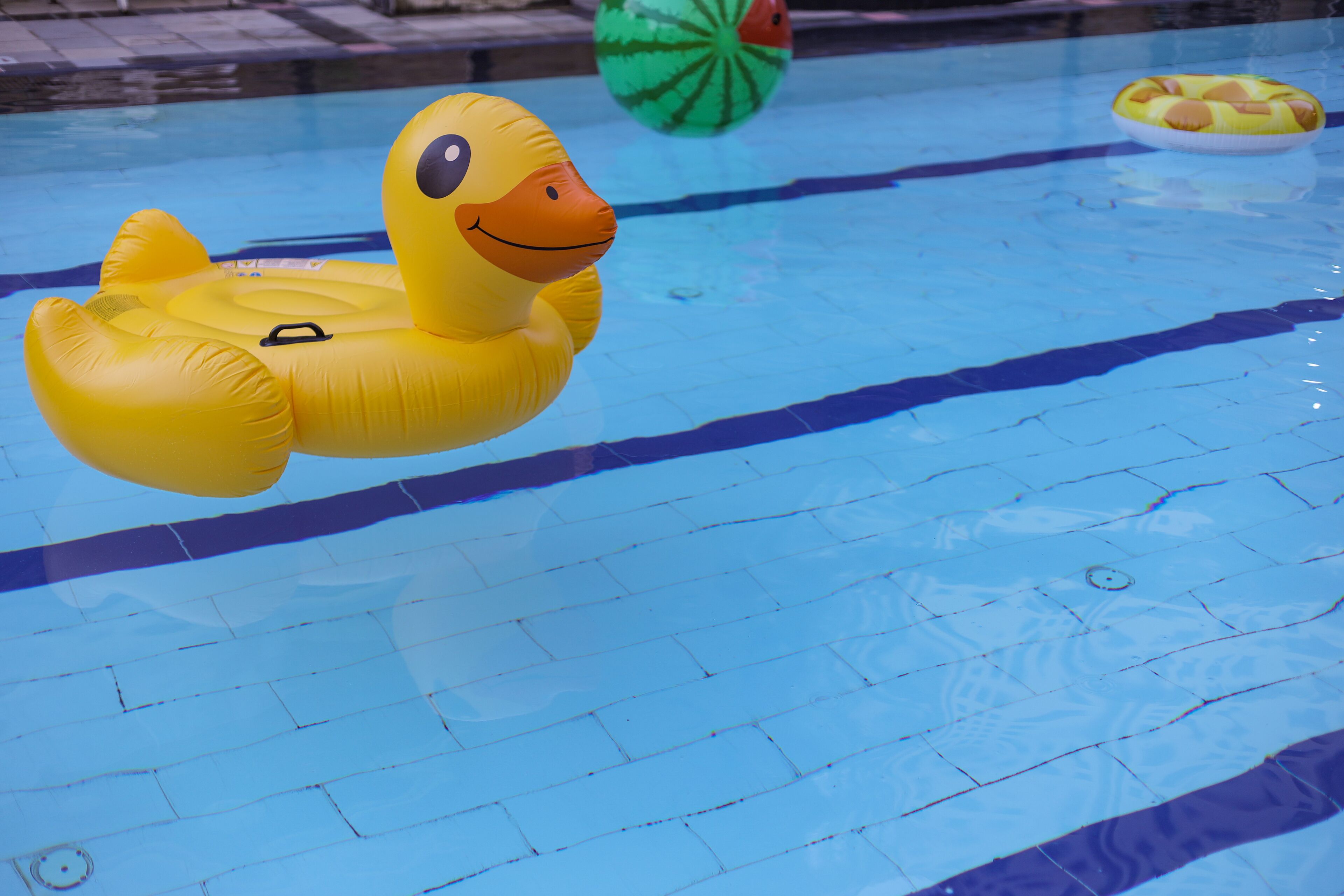 Una piscina con un galleggiante a forma di anatra gialla.
