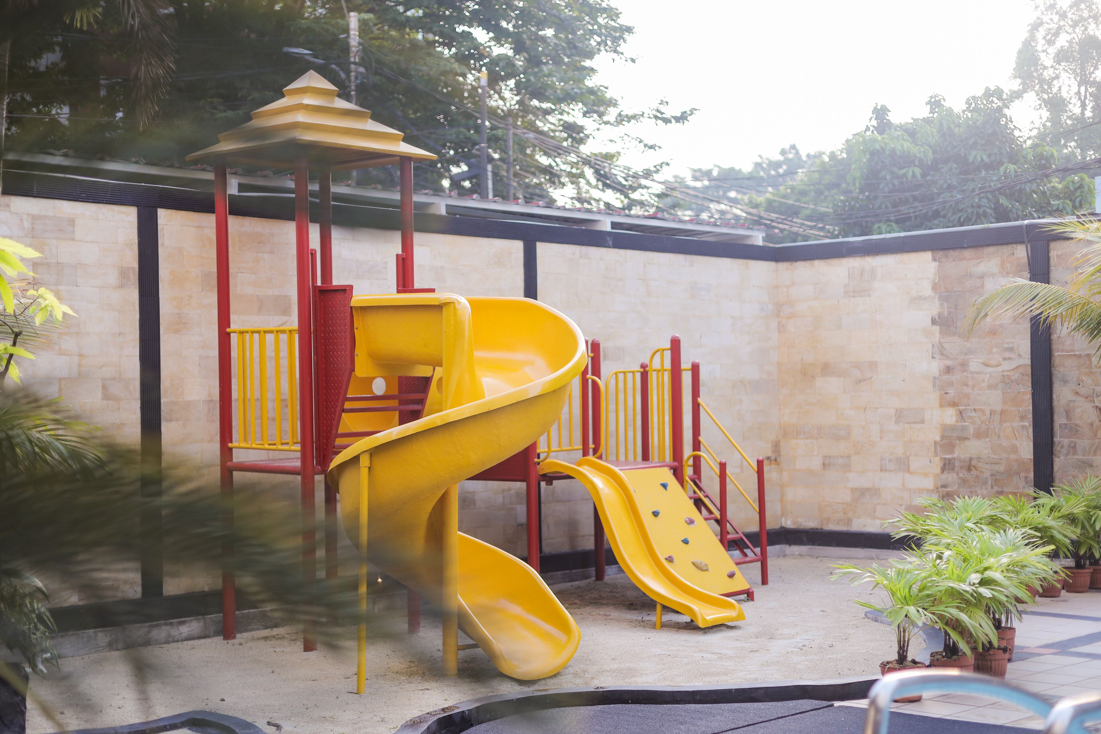 A playground with a yellow slide and climbing structures.