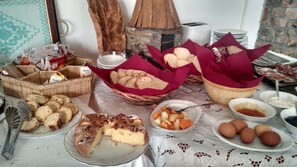 A buffet table with various food items including bread, cakes, and fruits. - Agriturismo Irghitula (Posada)