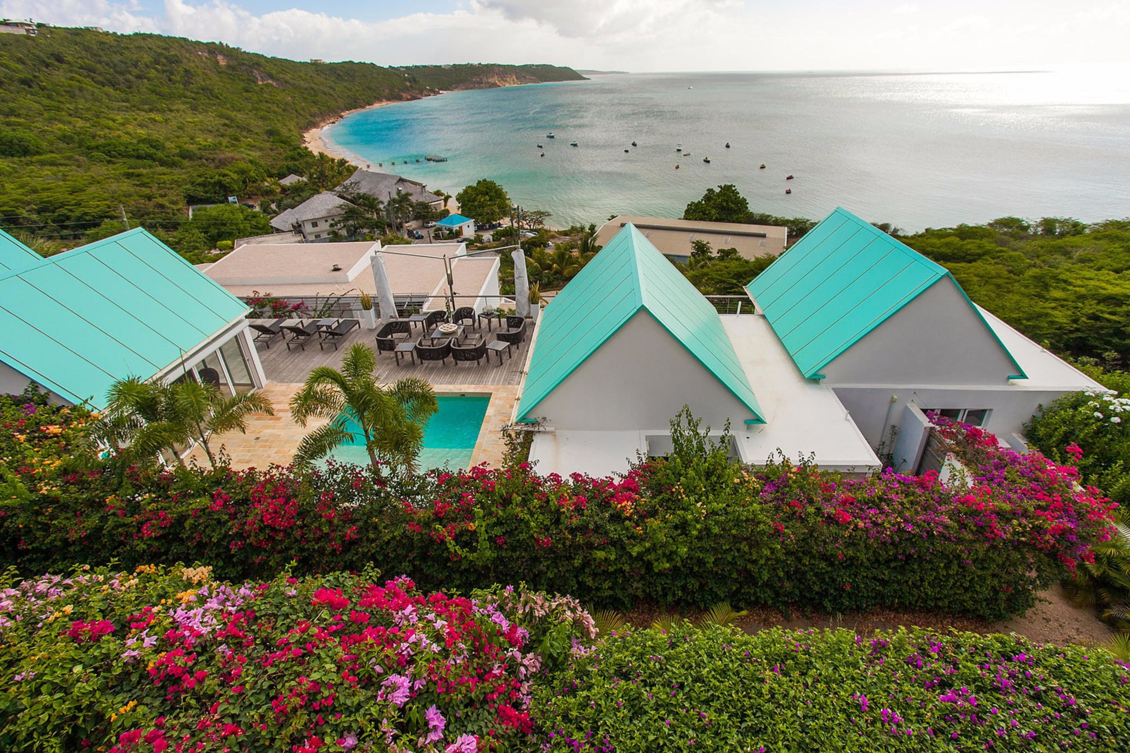 Un complexe hôtelier doté d’une piscine, d’un espace extérieur aménagé et offrant une vue sur la plage et l’océan.