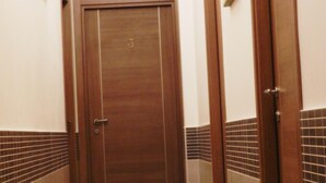 A hallway with a wooden door marked with the number 3, tiled walls, and a light fixture on the ceiling. - Vatican Rome B&B (Rome)