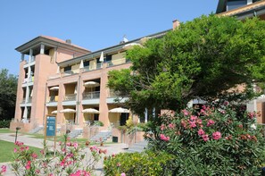 A multi-story hotel with a brick facade, balconies, and a sign indicating a reception area. - Continental Resort (Pisa)