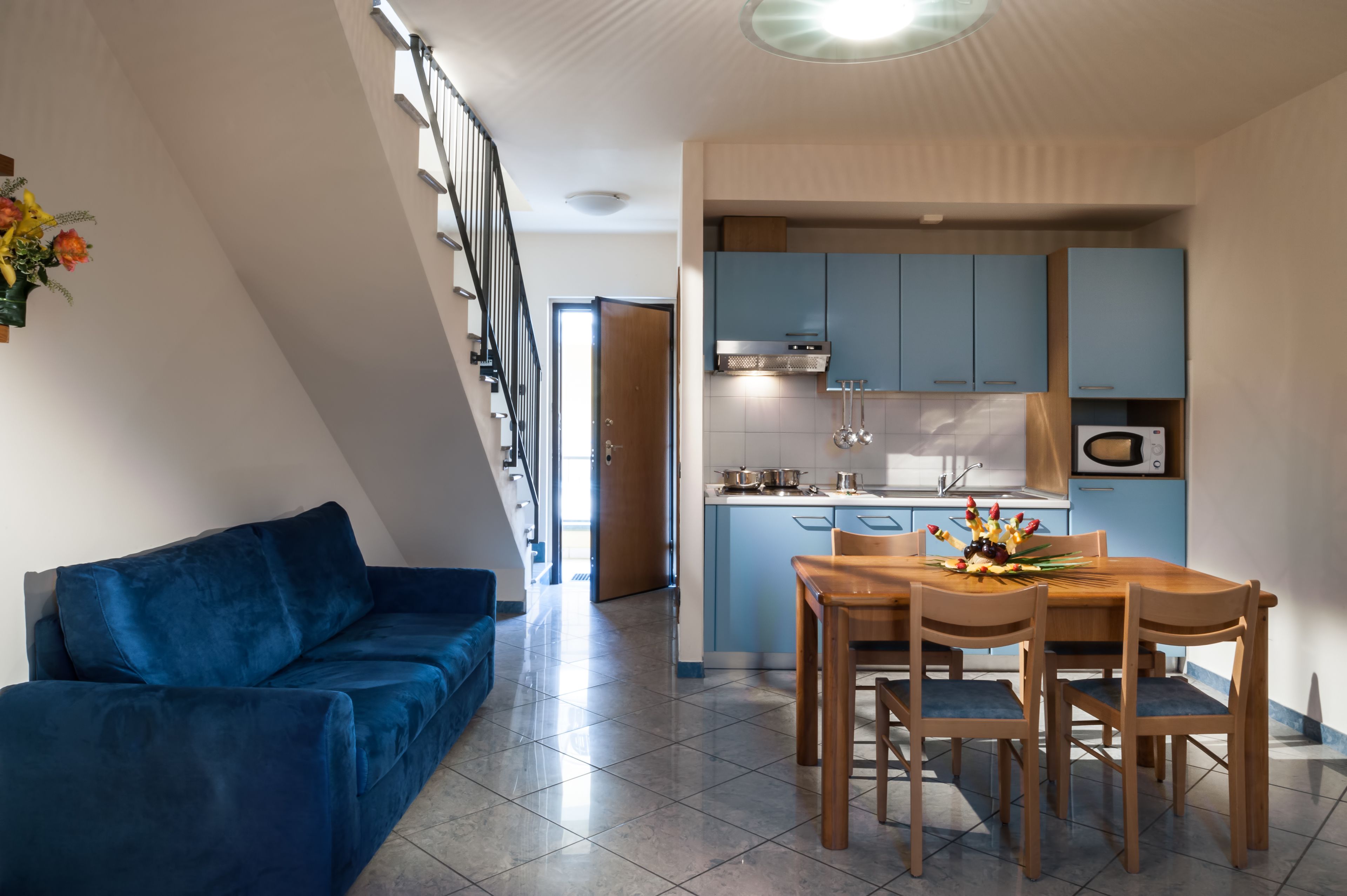 Un moderno appartamento con soggiorno, zona pranzo e cucina.
