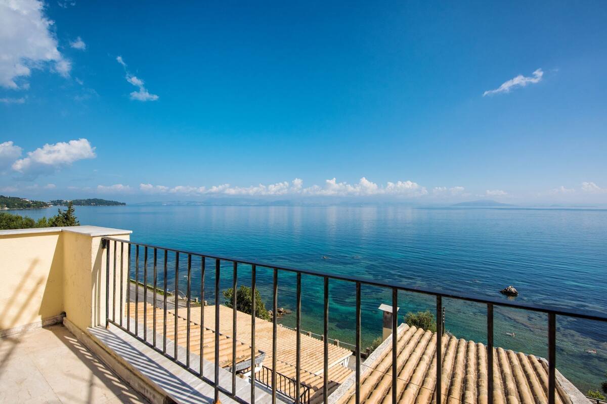 A balcony with a clear view of the sea and distant land.