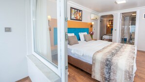 A bedroom with a large bed, a window, and a door leading to a bathroom. - Seatanbul Hotel (Istanbul)