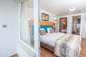 A bedroom with a bed, a window, a door, and a painting on the wall. - Seatanbul Hotel (Istanbul)