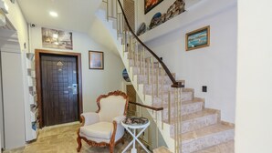 A staircase with a wooden handrail, a white chair, and a small table with a tray. - Seatanbul Hotel (Istanbul)