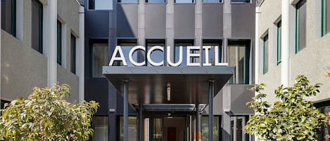 A modern building with a sign reading 'ACCUEL' and a welcoming entrance.