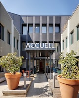Un edificio moderno con un letrero que dice 'ACCUEL' y una entrada acogedora.