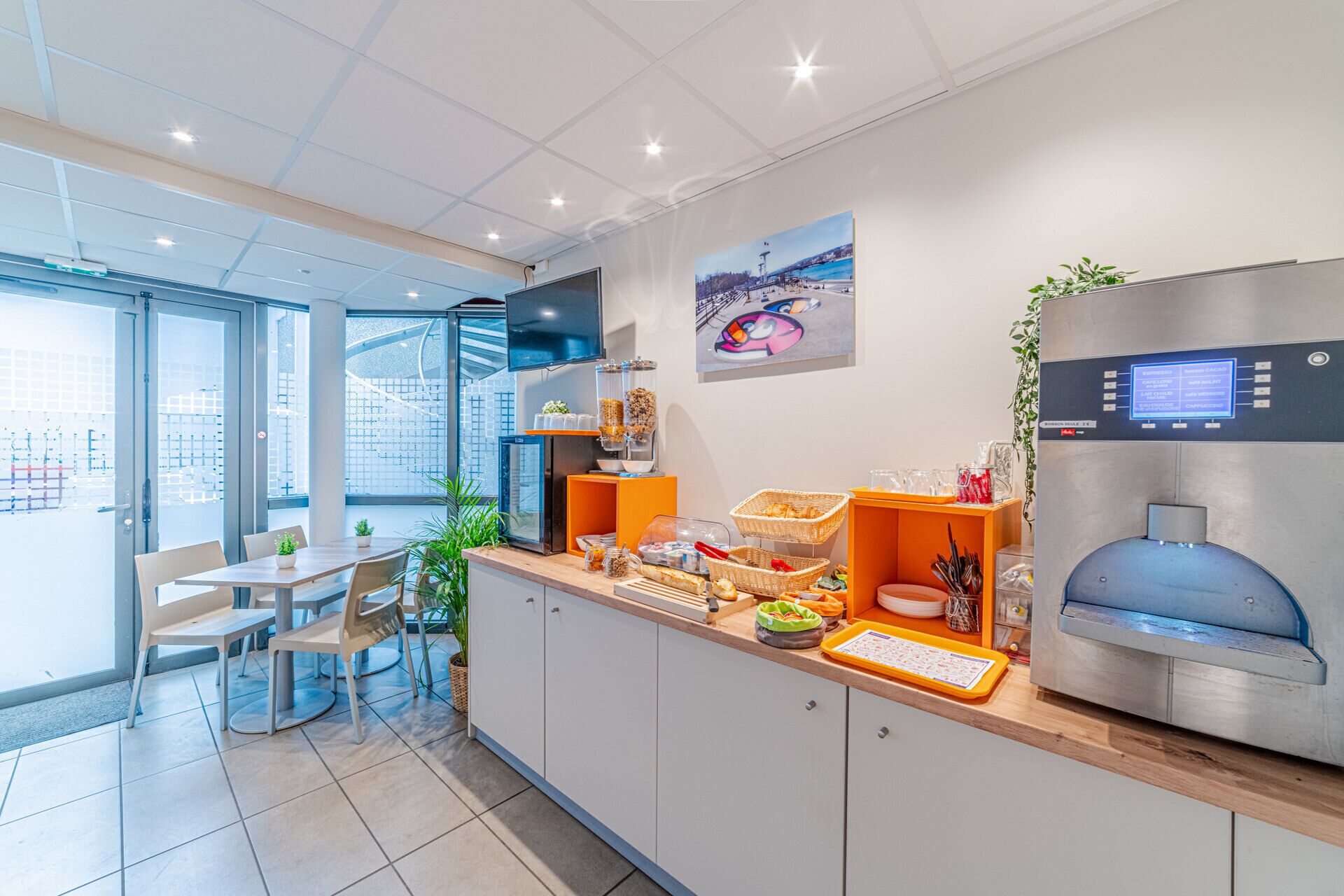 A modern kitchen with a coffee machine, breakfast items, and a digital display.