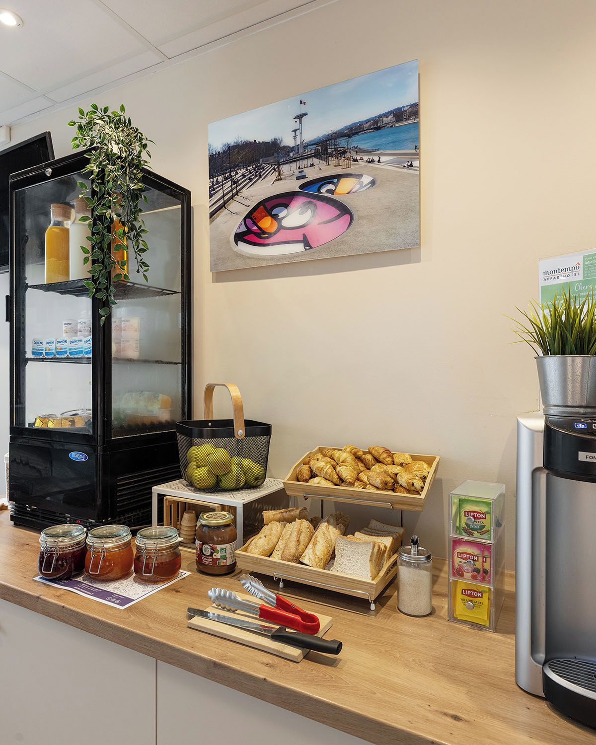 A breakfast bar with pastries, bread, and condiments.