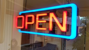 Un neon con la scritta 'OPEN' in caratteri rossi su sfondo blu.