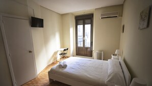 A bedroom with a bed, a chair, a desk, a TV, and a window. - Hostal MYD Los Perales (Madrid)