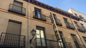 A building with multiple balconies, a street lamp, and a sign with the number 106. - Hostal MYD Los Perales (Madrid)