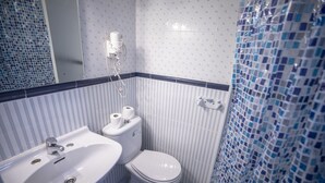 A bathroom with a white sink, toilet, and a shower area. - Hostal MYD Los Perales (Madrid)