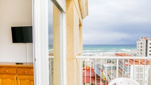 Ein Balkon mit Blick auf das Meer und ein Gebäude gegenüber.