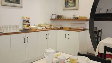 En morgenmadsbuffet med et udvalg af spiser samt kaffestation.