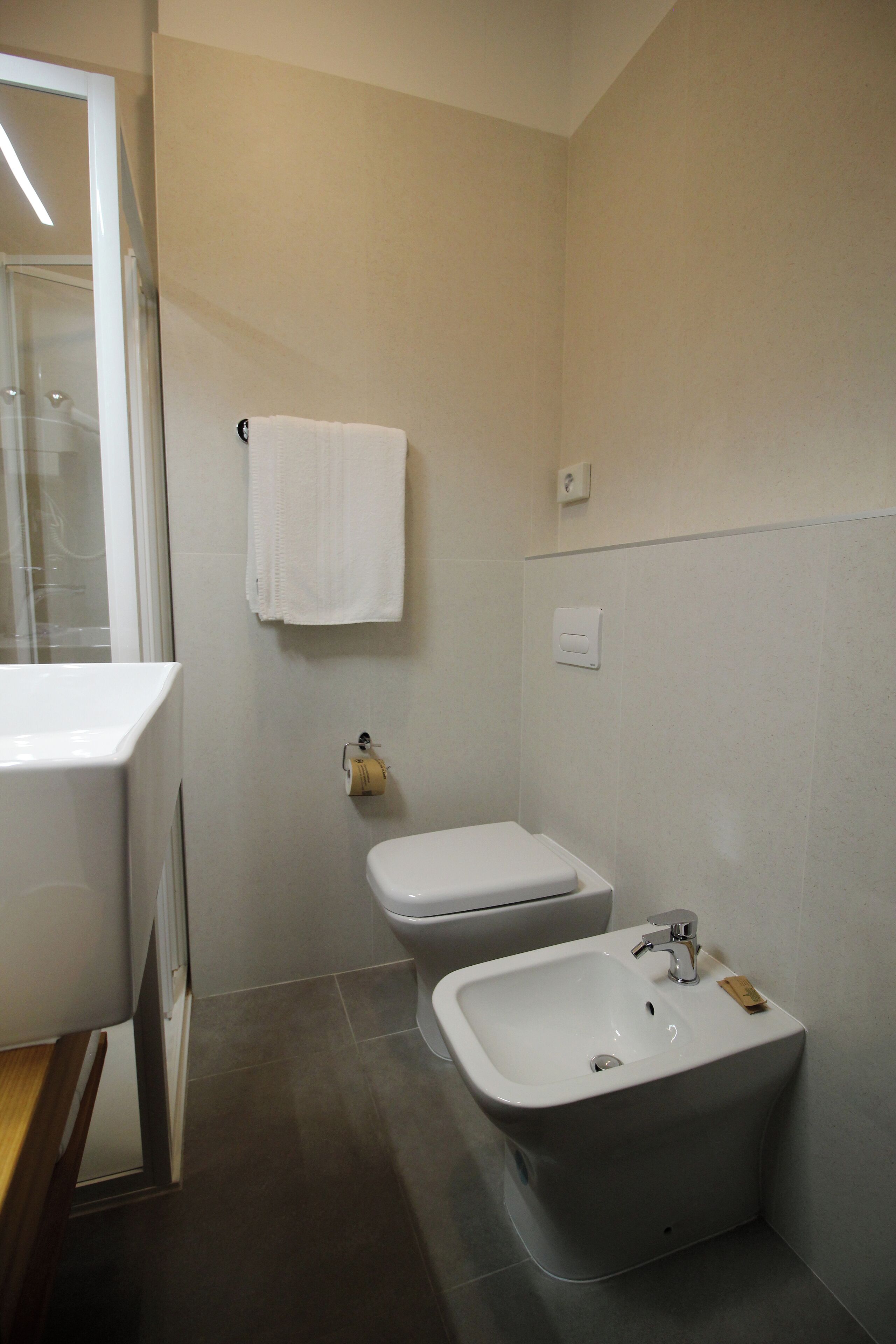 A bathroom with a toilet, bidet, and sink.