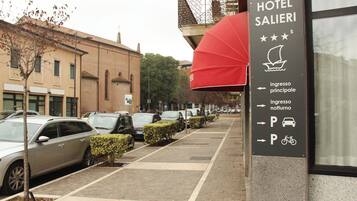A hotel sign with directions for parking and main entrance.