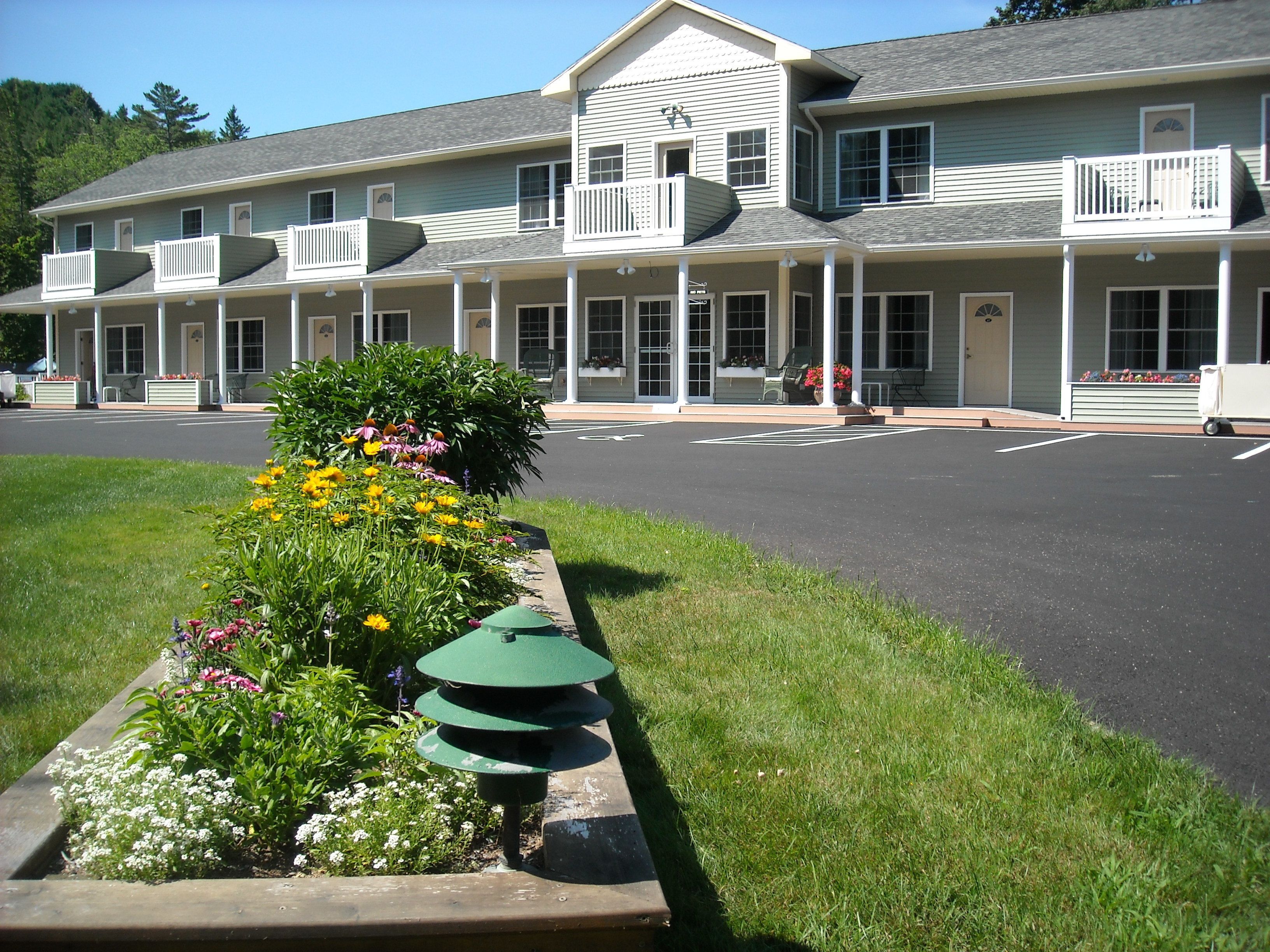 A two-story building with a covered porch and multiple windows.