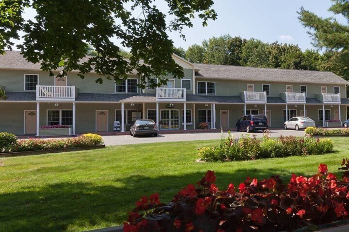 En række motelbygninger med parkeringsplads foran.