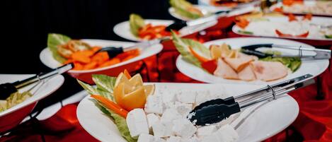 Una mesa de buffet con diversos alimentos y utensilios.
