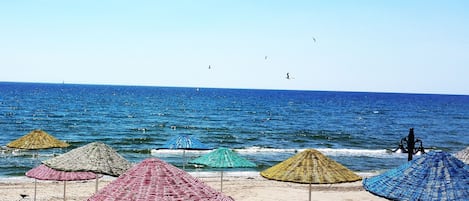 Privat strand, solstolar, parasoller och volleyboll