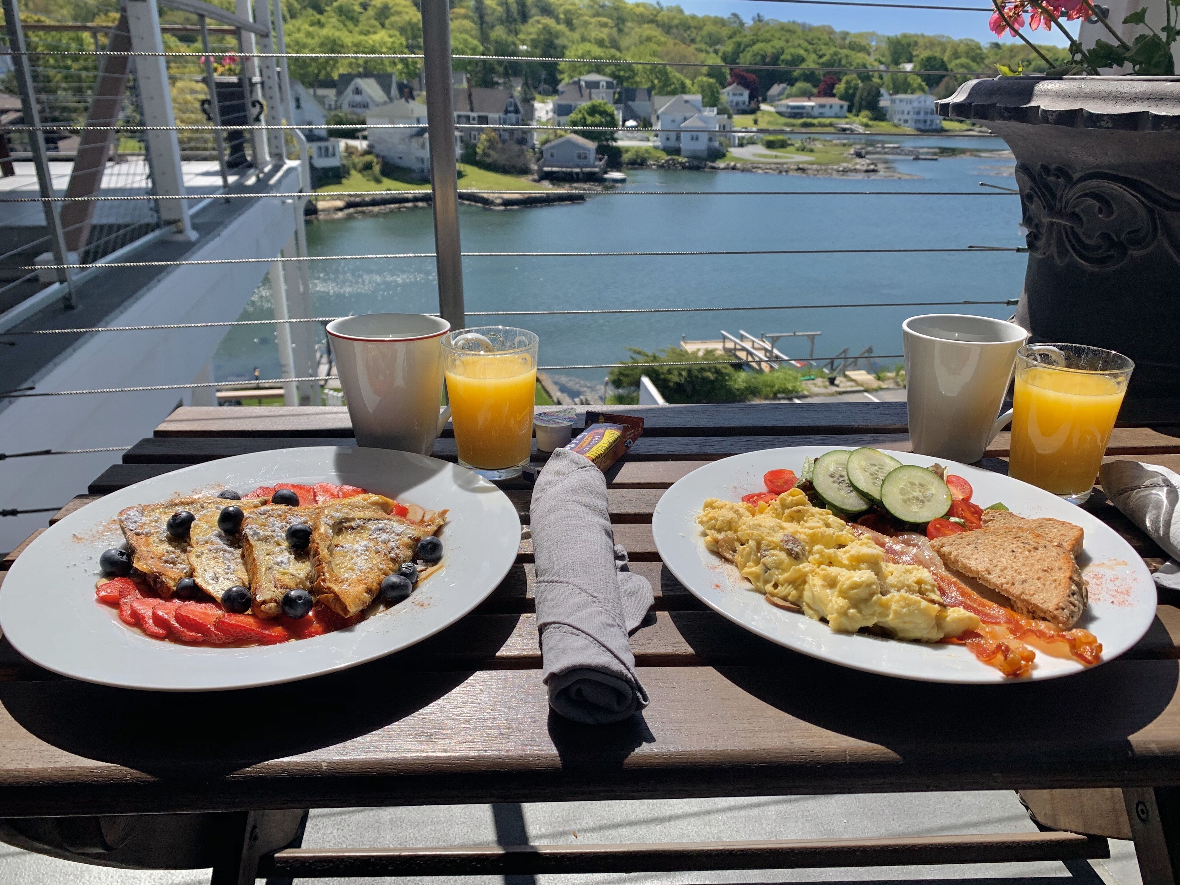 A table with breakfast plates, two glasses of orange juice, and a napkin.