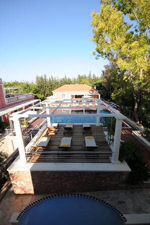 A rooftop pool area with lounge chairs and a view of a building in the background. - Metohi Georgila (Platanias)