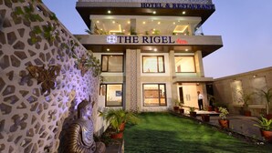 Un hôtel appelé «The Rigel», doté d’un design moderne, avec une pelouse bien entretenue et des statues décoratives.