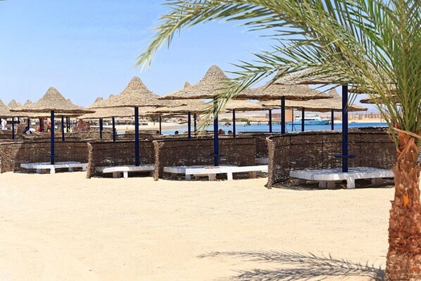 Playa privada, camastros, sombrillas y bar en la playa 