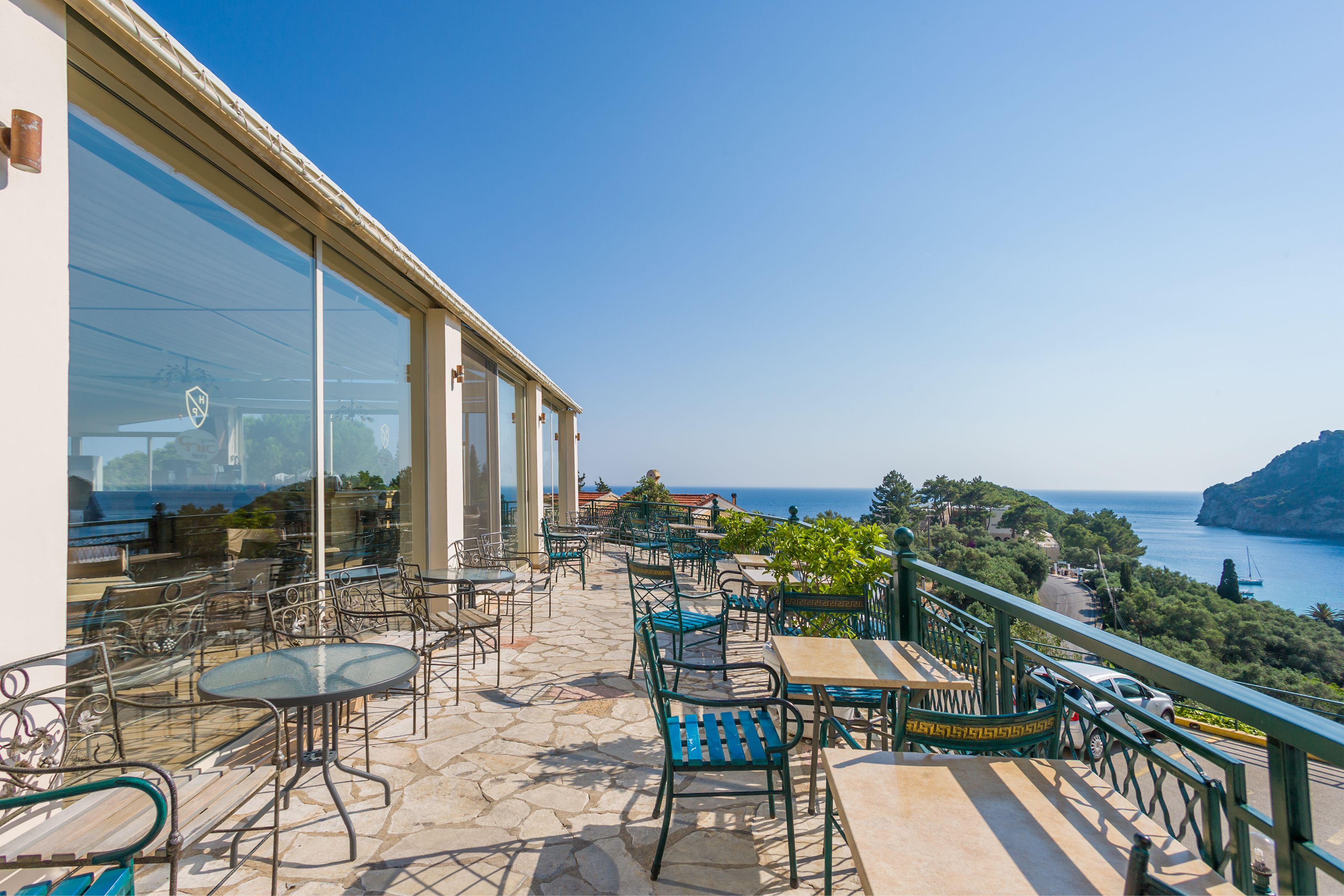 A terrace with outdoor seating and a view of the sea.