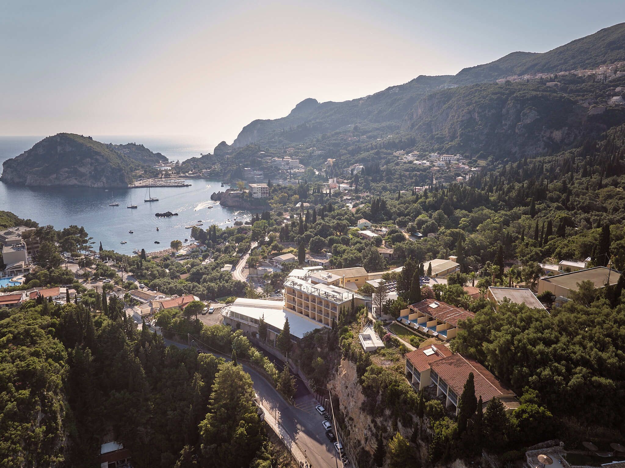 A coastal town with buildings, a road, and a body of water.
