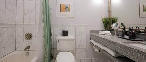 Un baño con bañera, inodoro y zona de lavamanos.