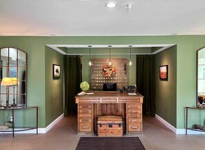A room with a wooden desk, a mirror, and a decorative wall panel.