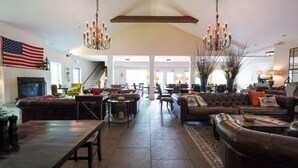 A spacious living room with a large American flag, a fireplace, and a chandelier. - On The River Inn (Woodstock)