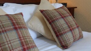 A bed with white linens and plaid-patterned pillows. - The Kenbridge Hotel (Castle Douglas)
