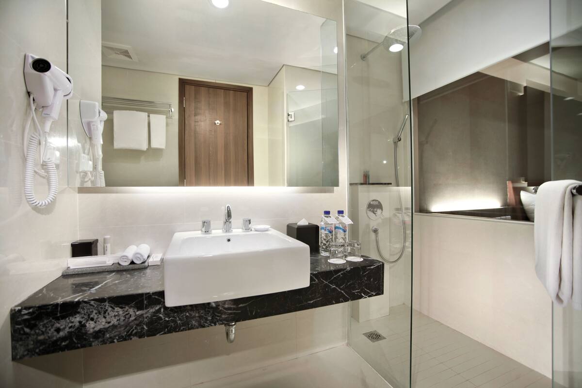 deluxe room | bathroom | shower, rainfall showerhead, free toiletries, slippers