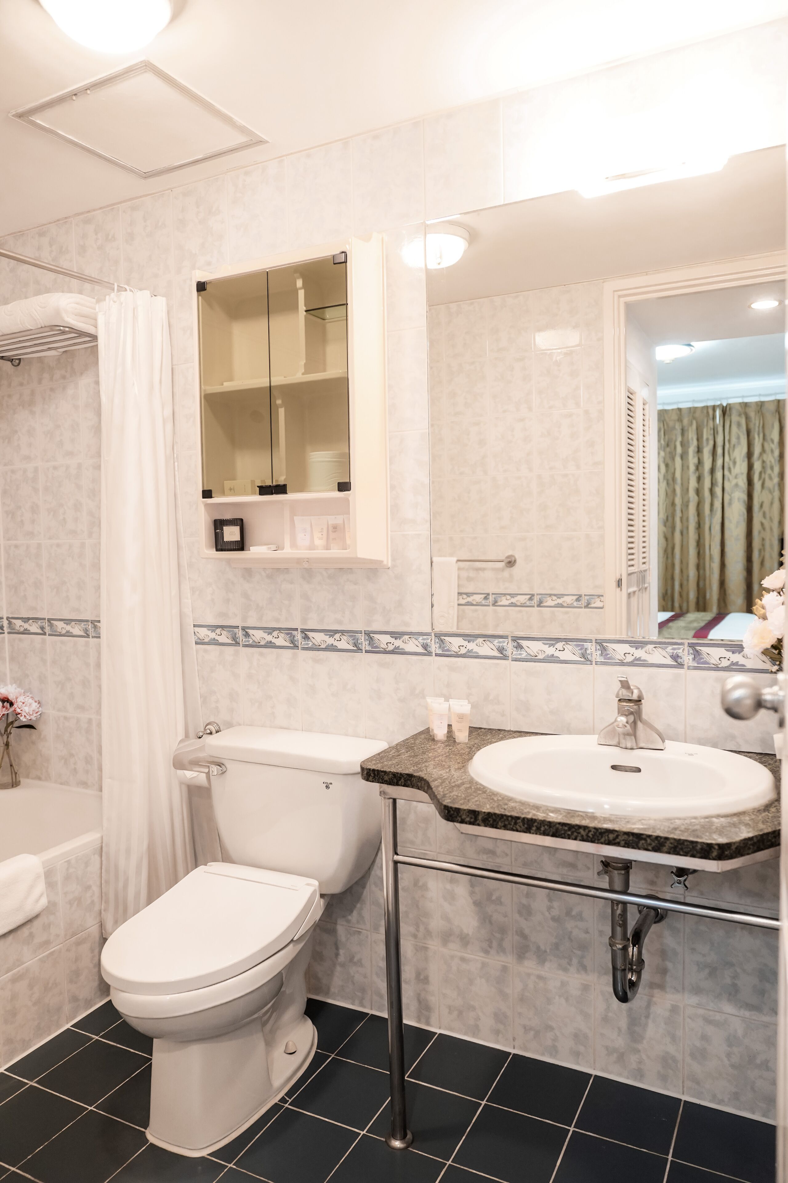 Ein Badezimmer mit Toilette, Waschbecken und Duschbereich.