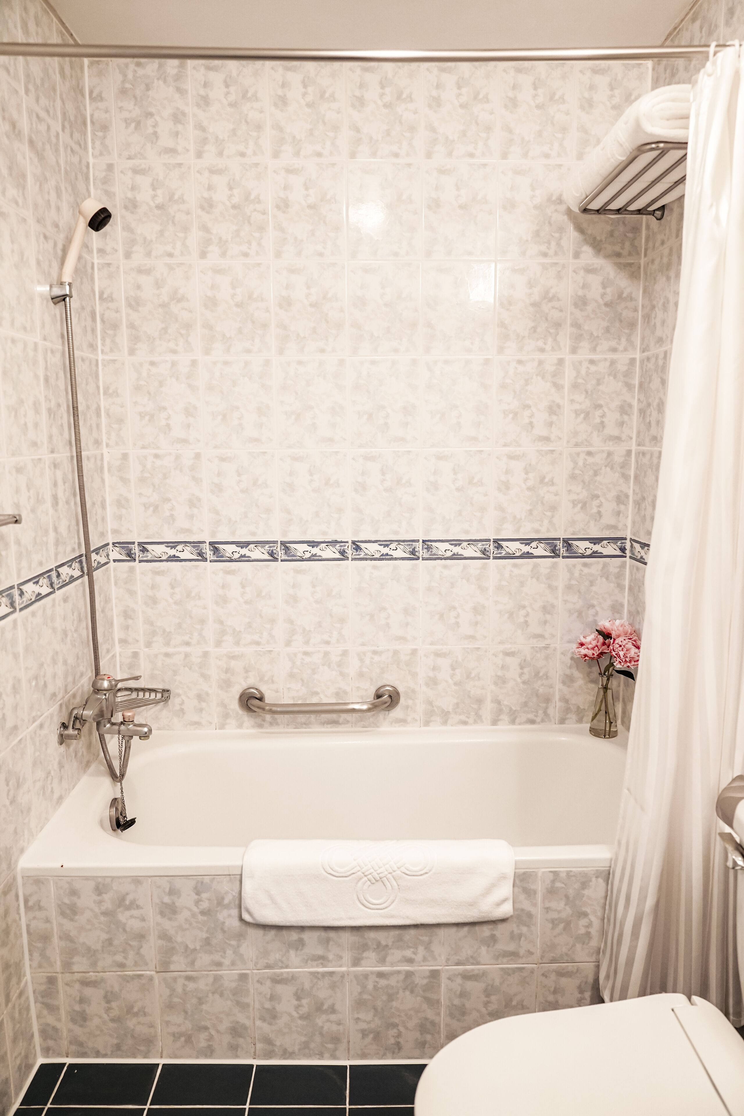 Un baño con bañera, ducha e inodoro.