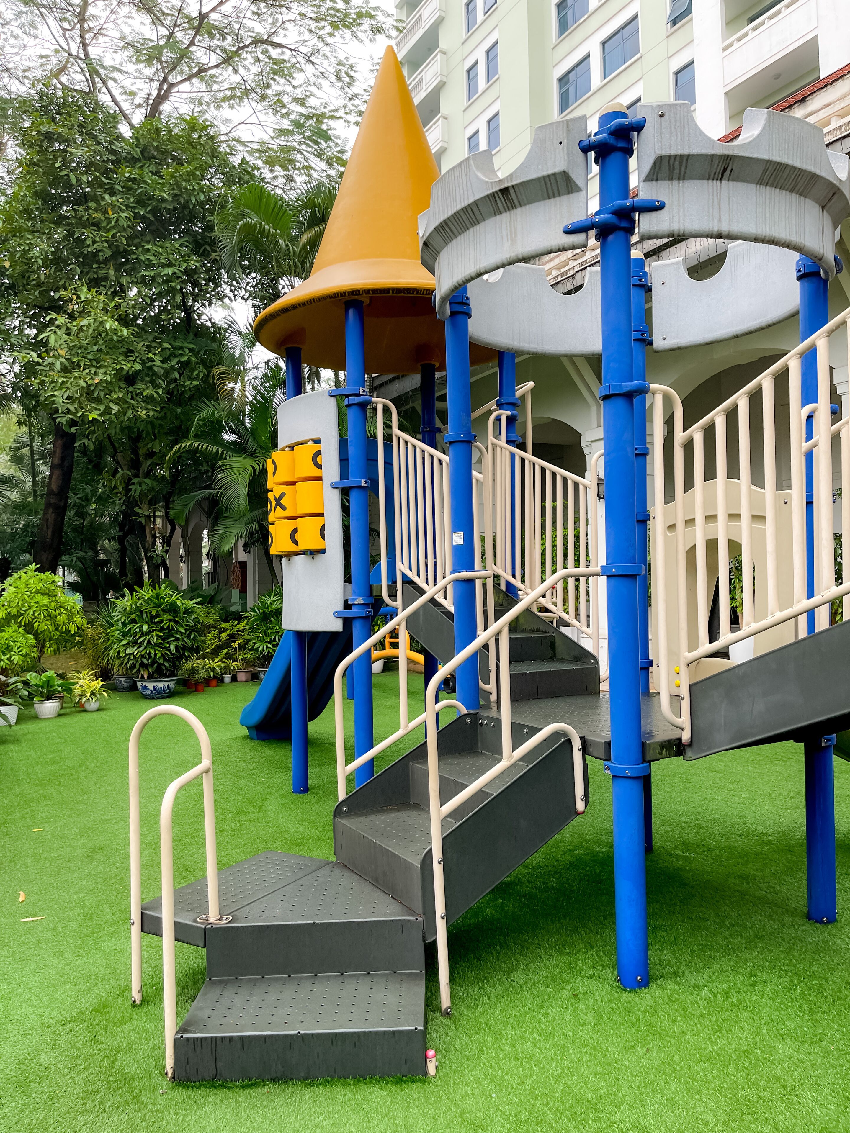 A playground with a slide, climbing structures, and steps.