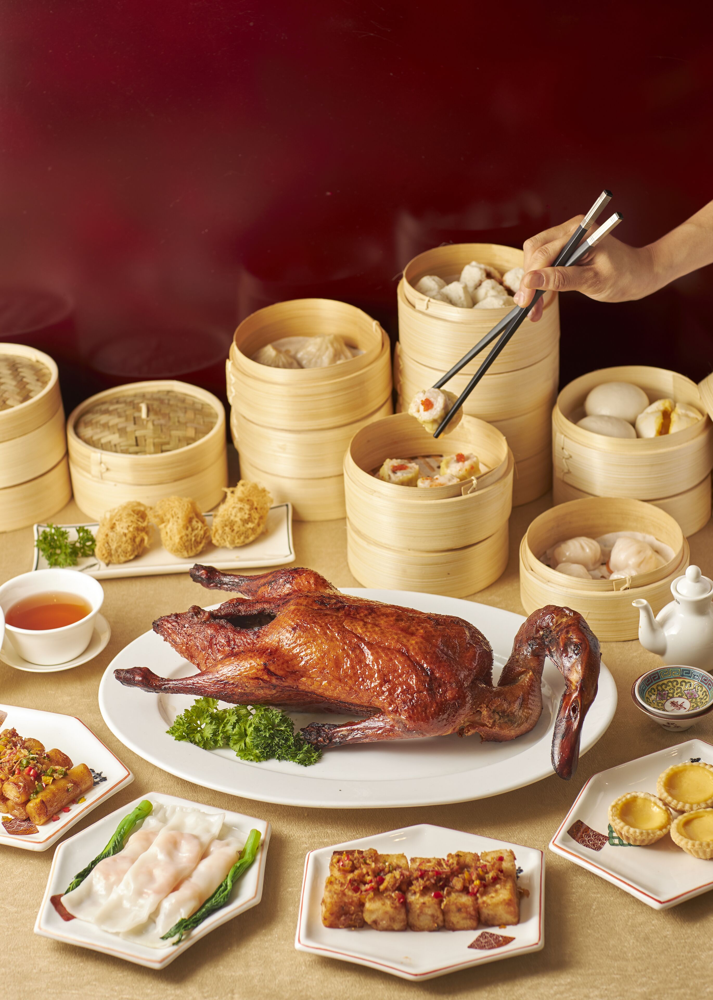 Variedad de platos chinos, entre ellos un pato asado completo, dumplings y otros acompañamientos.