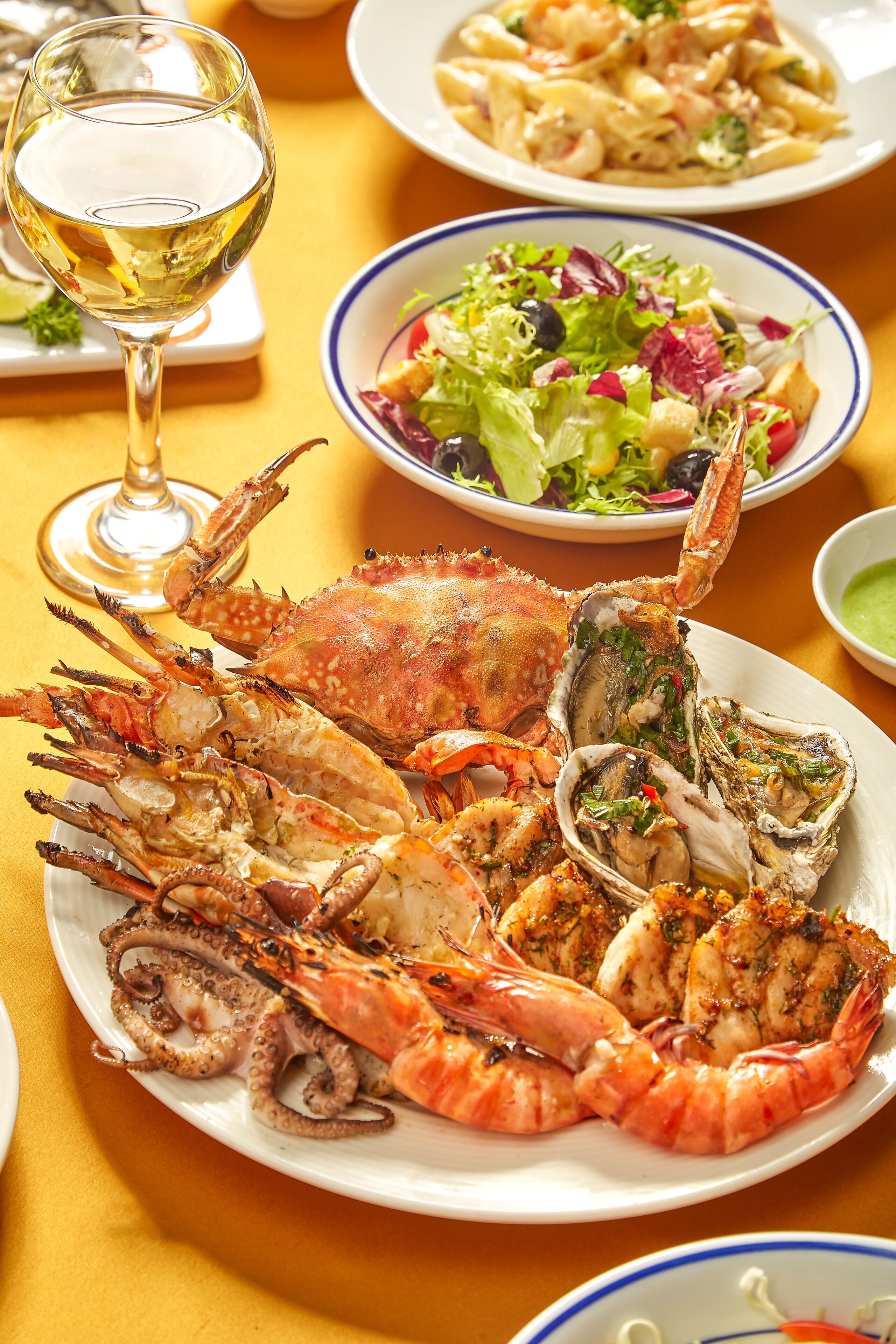 Un plateau de fruits de mer comprenant du crabe, des huîtres et des crevettes, présenté sur une assiette.