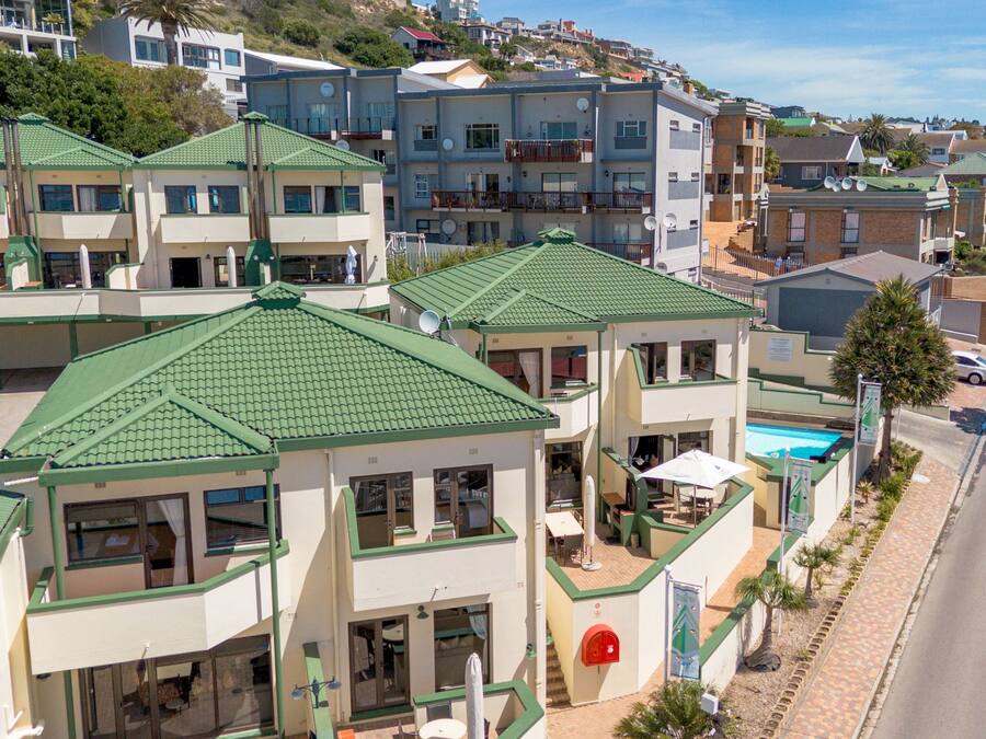 Hotel com vários andares, piscina no andar térreo, varandas em cada pavimento e vista para o bairro ao redor.