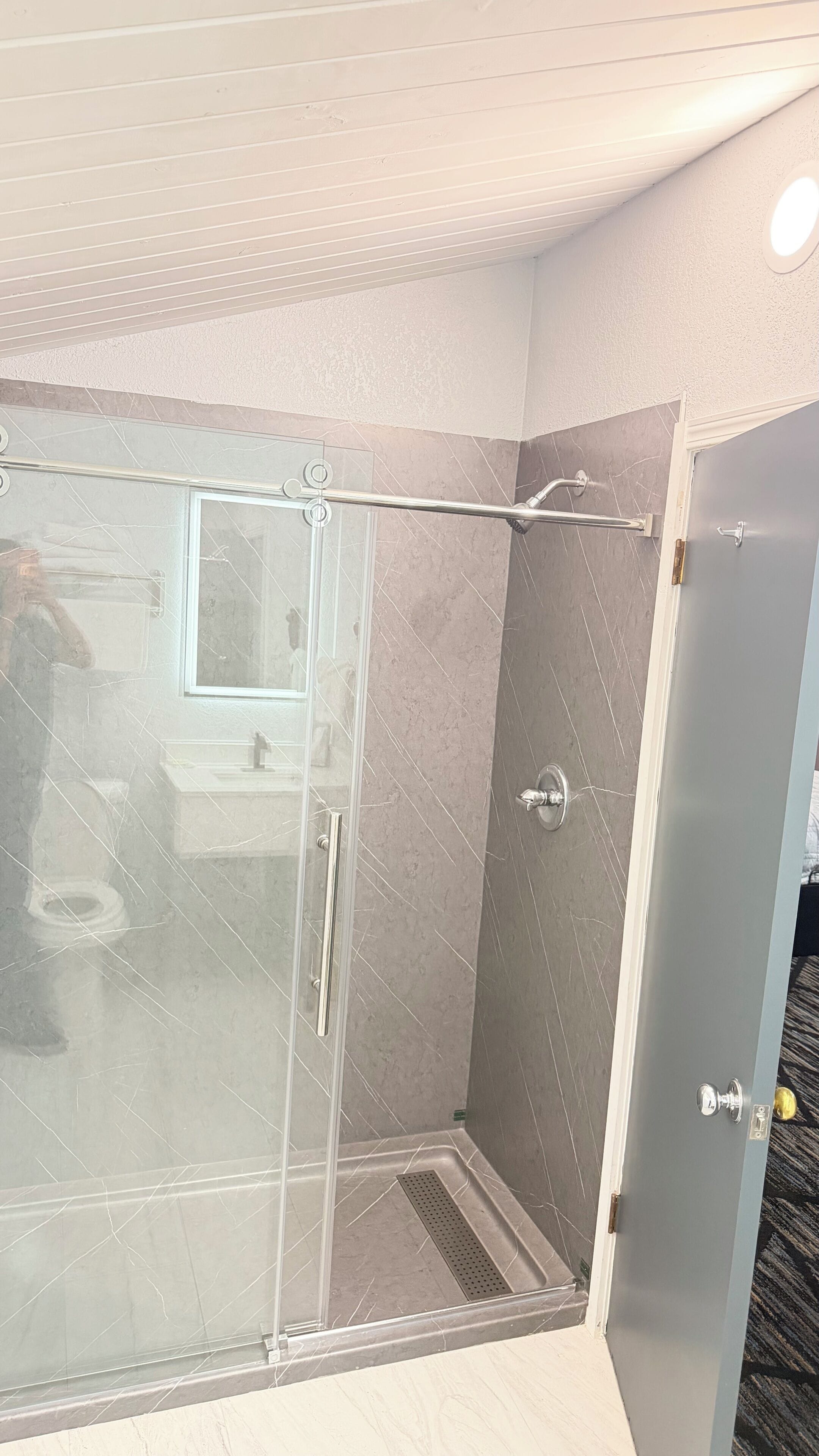 A modern bathroom with a glass shower enclosure, a sink, and a toilet.
