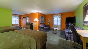 A hotel room with two beds, a desk, a chair, a television, and a sofa. - Highway Inn (Paris)