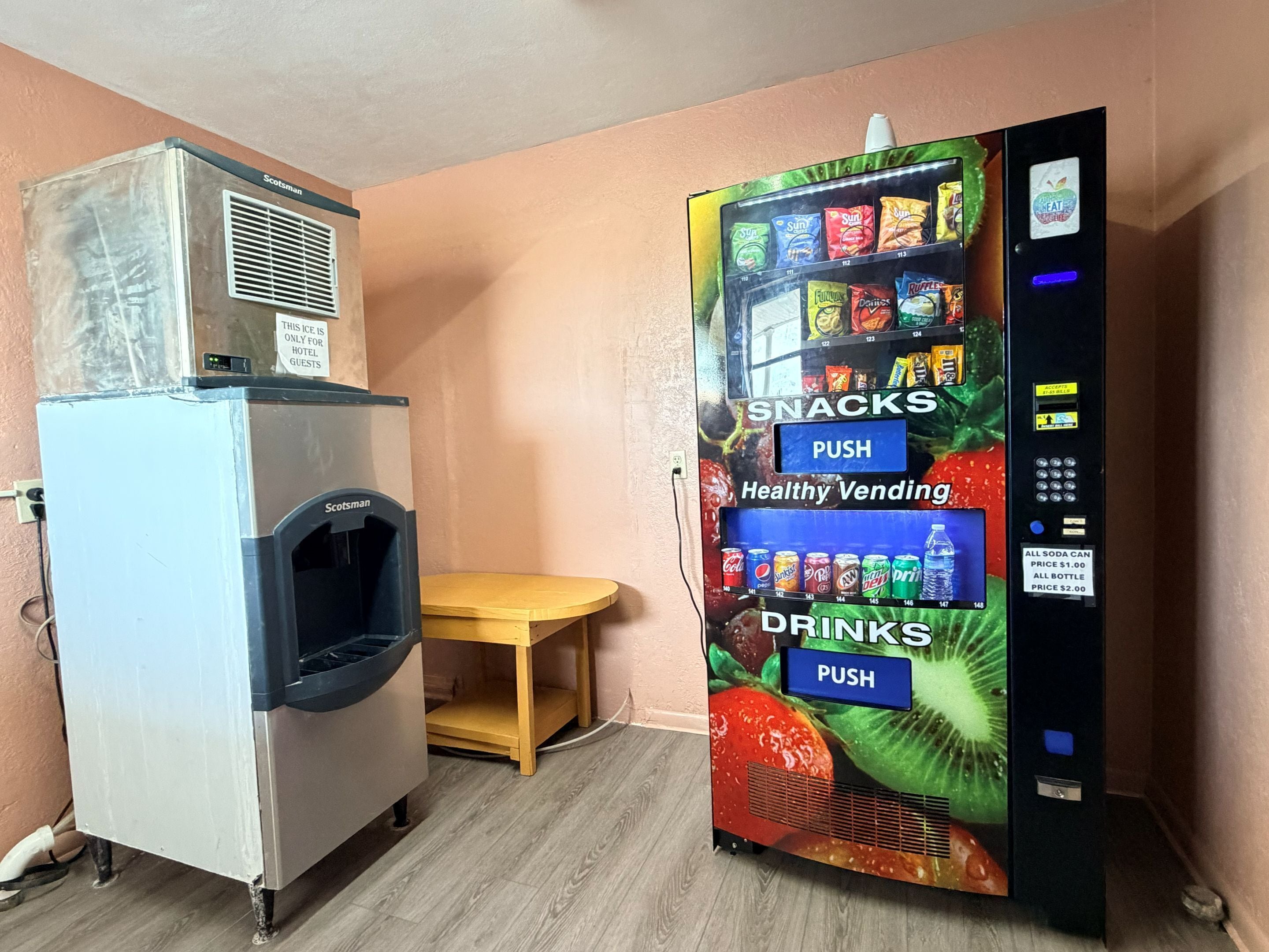Une chambre d’hôtel équipée d’un mini-bar et d’un distributeur automatique proposant des collations et des boissons.