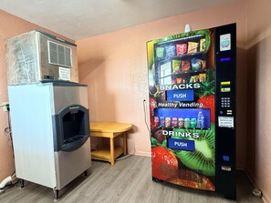 Une chambre d’hôtel équipée d’un mini-bar et d’un distributeur automatique proposant des collations et des boissons.